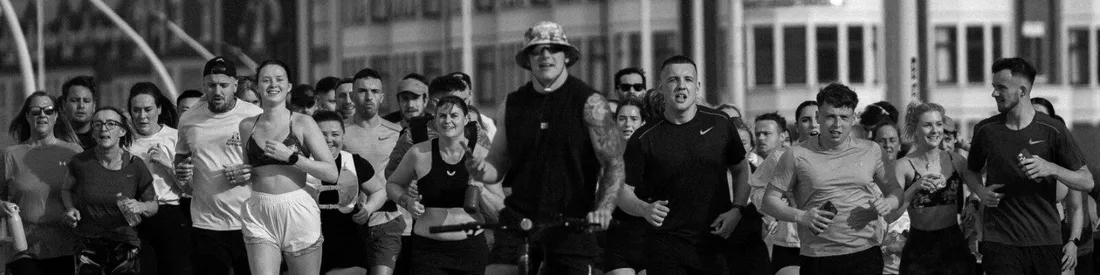 Fortis Run Club running towards the camera in a wide group, in black and white